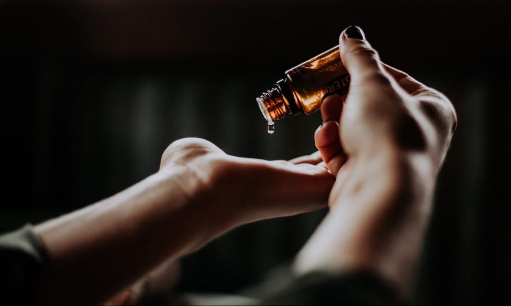 Person holding an amber glass bottle