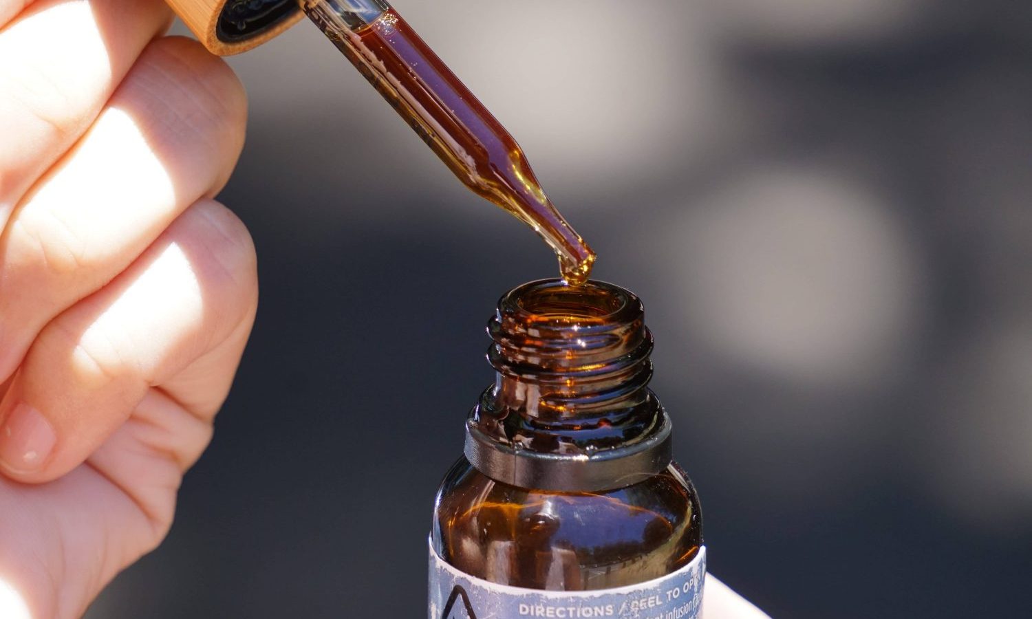 person holding brown glass bottle