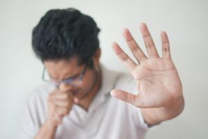 a man holding his hand up in front of his face