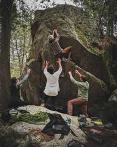 Group of people in white long sleeve shirt and green pants standing on rocky ground